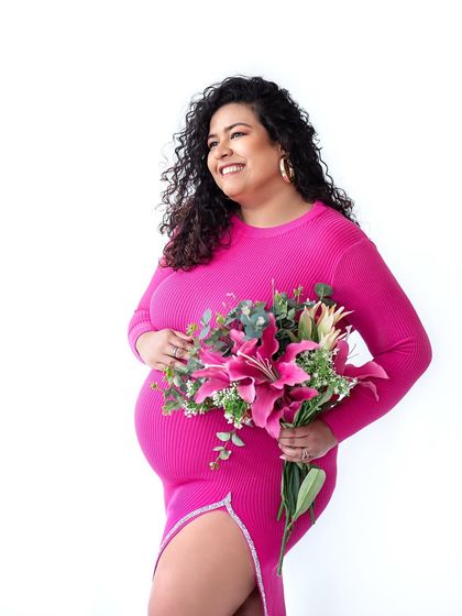 A beautiful solo shot capturing the radiant glow of motherhood, complemented by a stunning floral arrangement.