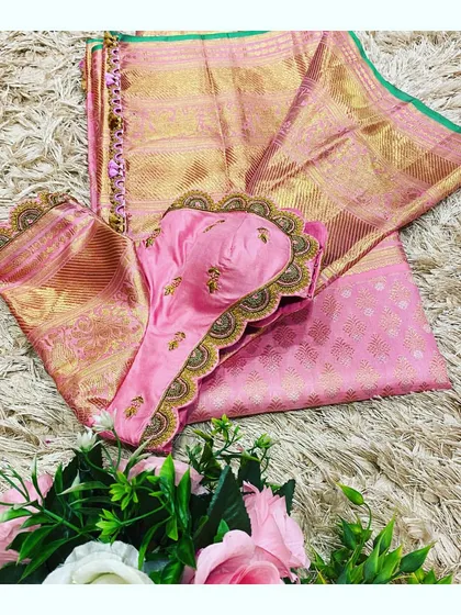 A flat lay of the pink saree and blouse, showcasing the hand-krosha tassels and the delicate embroidery work.