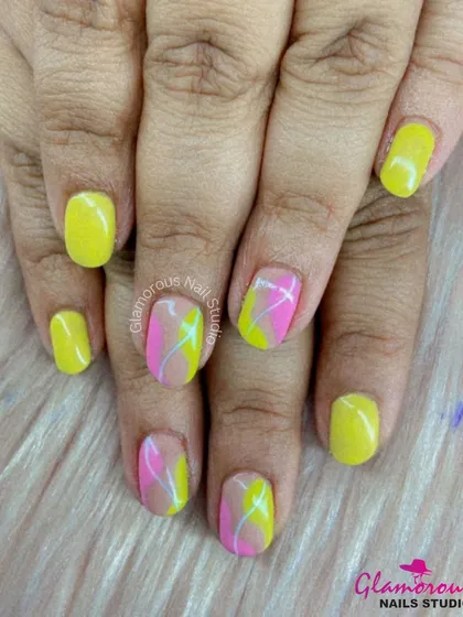 A fun and summery design with a mix of solid yellow nails and accent nails featuring abstract swirls of pink and yellow.