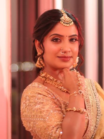 A thoughtful pose highlighting the intricate maang tikka and jewelry. The makeup is kept clean and radiant to let the traditional elements shine.