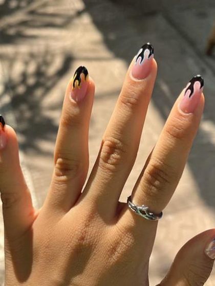 A different take on flame nails, this time with a classic black and pink design on long, elegant almond-shaped extensions.