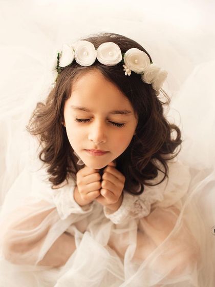 A serene and angelic portrait. Her closed eyes and peaceful expression create a truly beautiful and timeless image against a soft white background.