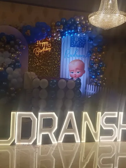 Another angle of the Boss Baby themed stage, showing how the balloon garlands and character cutouts frame the entire setup.
