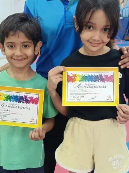 Two happy students show off their "Awesomeness" certificates.