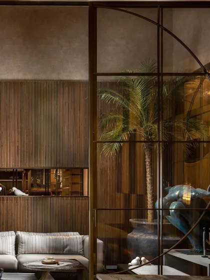 This custom millwork design features a muted and earthy color palette. The vertically grooved wood paneling includes an inset display niche, demonstrating our focus on choosing the right materials and details for a space.