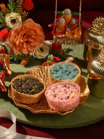 A close-up of my assorted mini ghewars, with flavours like chocolate, rose, and blueberry, arranged on a golden leaf-shaped platter.
