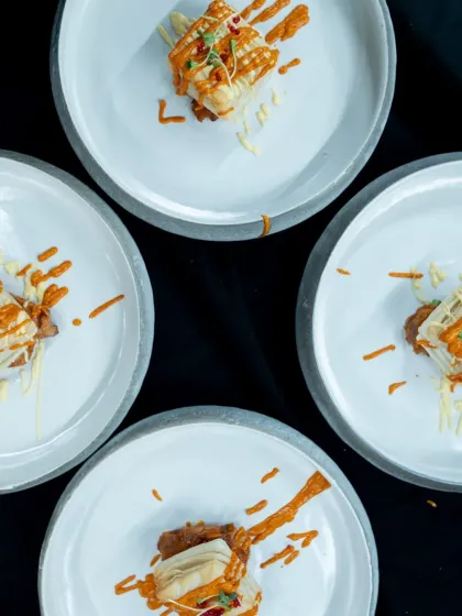 A stunning top-down shot of four plates of our artfully crafted ratatouille, just before being served. The presentation is as important as the taste, designed to be a feast for the eyes as well as the palate.