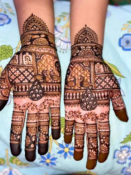 A semi-filled traditional design for guests, featuring peacock motifs within ornate window-like frames on the palms.