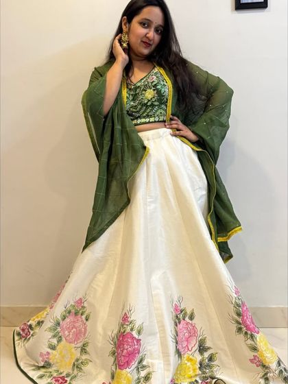 A confident pose in the hand-painted lehenga, showing how the contrasting green dupatta brings the whole look together.