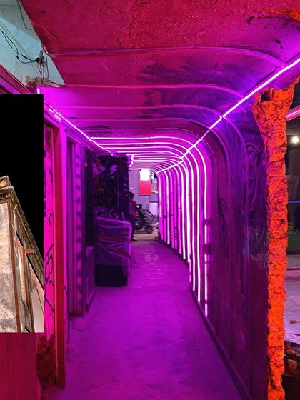 A neon-lit corridor in a Hauz Khas bar, blending modern design with the area's rustic charm.