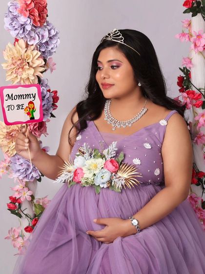 A playful and sweet shot with a "Mommy to be" prop, highlighting the joy and excitement of this special time. The floral swing makes the perfect backdrop.