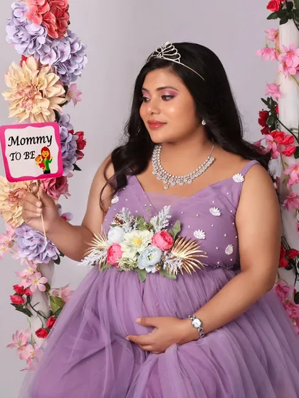 A playful and sweet shot with a "Mommy to be" prop, highlighting the joy and excitement of this special time. The floral swing makes the perfect backdrop.