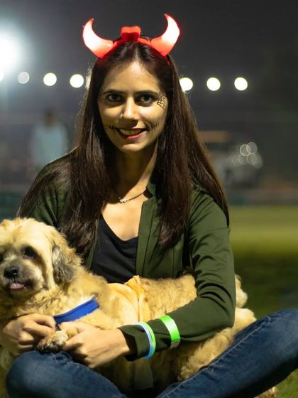 A pet parent in devil horns poses with her fluffy companion at our Halloween party. I encourage everyone, humans included, to get into the spooky spirit.