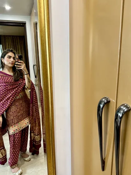 A mirror selfie in a classic maroon printed salwar suit. This is a timeless look that is perfect for family gatherings or smaller festive events.