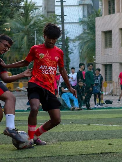 Our U18 player in the red Atlanta SG5FA kit, skillfully shielding the ball from an opponent in the MBPL.