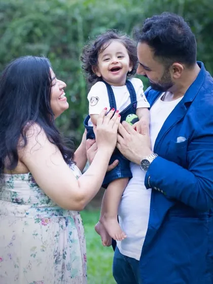The parents' loving gaze on their laughing child says it all. Capturing these interactions is the essence of family photography.