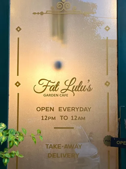The elegant glass door of my Garden Cafe, open every day from 12pm to 12am for dine-in, takeaway, and delivery.
