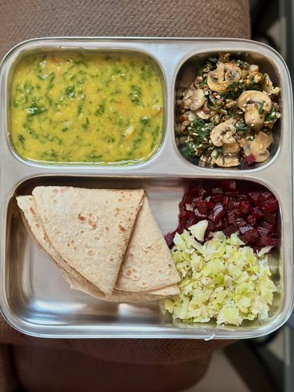 A vibrant plate of chapati, dal palak, and a colorful mix of sautéed cabbage and beetroot, with a side of mushroom palya.