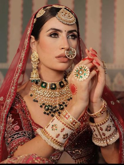A close-up on the jewellery for this look. A heavy kundan and green-beaded necklace, paired with a large nath and maang tikka.