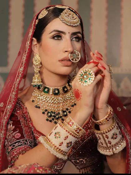A close-up on the jewellery for this look. A heavy kundan and green-beaded necklace, paired with a large nath and maang tikka.