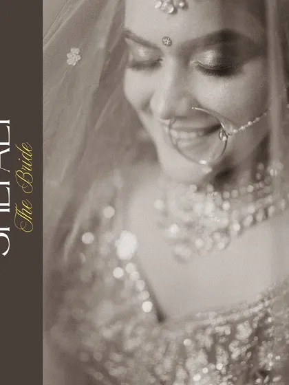 A serene black and white portrait of the bride, her gentle smile captured under the soft light of her veil. This timeless shot focuses purely on her emotion and beauty.