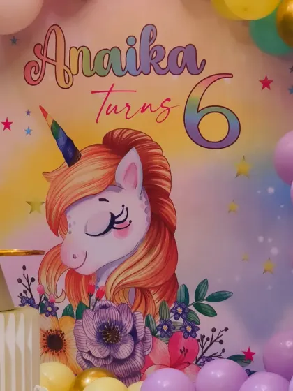 The centerpiece of our unicorn theme, featuring a custom backdrop with Anaika's name and age. The soft colors and charming unicorn illustration set a magical tone for the entire event.