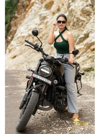 A solo portrait of the bride looking confident and stylish with the motorcycle. This highlights her personality and the adventurous theme of the shoot.