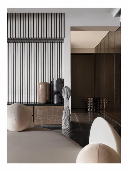Obscure corners are opportunities for art. In this entryway, we used curated monochromatic pieces to play with form rather than color. A striped wall panel adds a graphic element, while the dark flooring grounds the space, setting a sophisticated tone for the rest of the home.