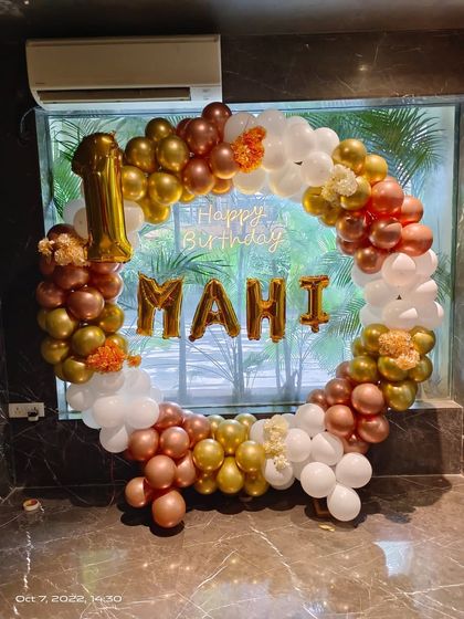 A lovely circular balloon arrangement for Mahi's first birthday. The rose gold, white, and gold balloons create an elegant frame, personalized with foil name and number balloons.