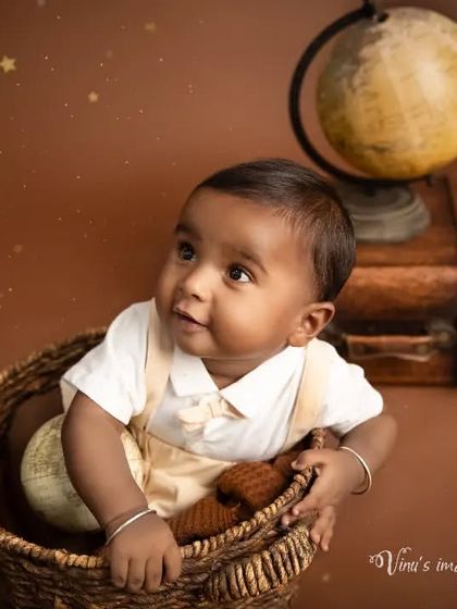 Dreaming of faraway places. This sweet portrait captures a baby looking up with wonder from inside a basket, part of our vintage explorer-themed set.