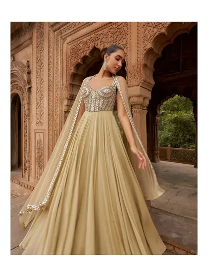This gown features an elegant corseted bodice and attached cape-like sleeves that add a touch of drama. The fluid fabric ensures you can move with ease and confidence.