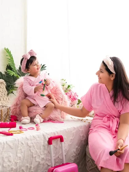 The giggles continue. This wider shot of the mother-daughter spa day shows the full setup, complete with a mini suitcase and accessories, designed for imaginative play.