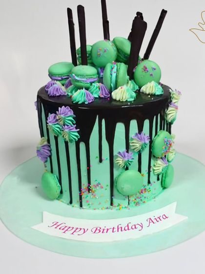 A vibrant macaron drip cake in shades of mint green and purple. This fun and colorful cake is a feast for the eyes and the taste buds.