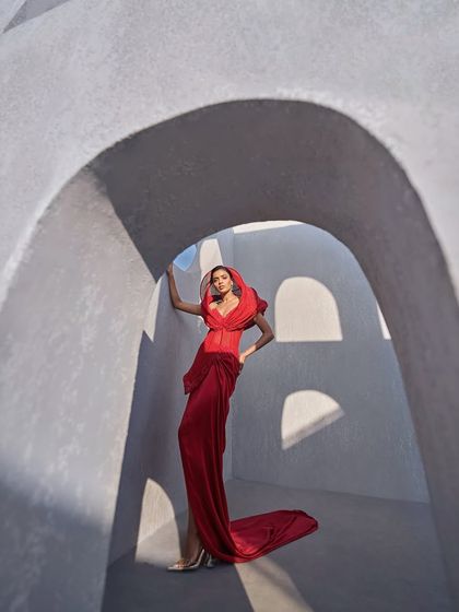 A full view of the structured red hooded gown, where the rich fabric creates an aura of power and the tailored silhouette offers a flawless fit.