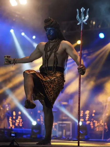 Another powerful portrayal of Lord Shiva, captured in a dynamic pose. The stage lighting highlights the student's physique and the character's intensity.