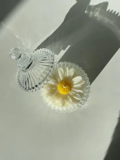 This daisy candle is hand-poured into a stunning vintage-style glass carousel jar with a lid. It's a beautiful decorative piece, even when not lit.