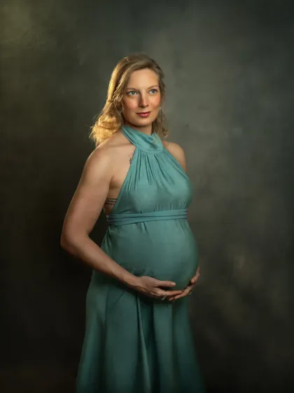 A duplicate of ID 3, this classic maternity portrait features an expecting mother in a beautiful sea-green gown. The studio lighting highlights her form and the texture of the fabric, creating a timeless, painterly effect.