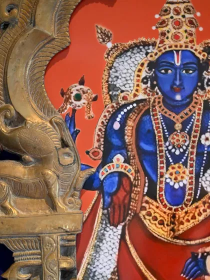 A detail shot of the Vishnu painting, showing the fine details of the jewelry and clothing, characteristic of the Tanjore style that influenced this piece.