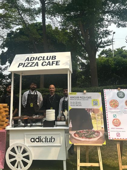 My team proudly standing at the branded "adiclub Pizza Cafe" cart during the Adidas event. We ensure our service and setup reflect the professionalism of our corporate clients.