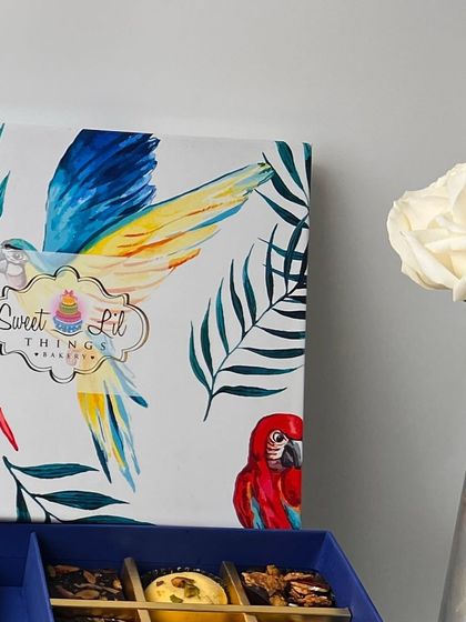 A close-up detail of our parrot-themed gift box, showcasing the quality of the print and the elegant "Sweet Lil Things" branding.
