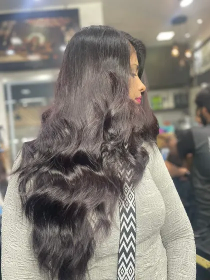 A beautiful example of long, dark hair styled into voluminous, glossy waves. This look is elegant, timeless, and full of body.