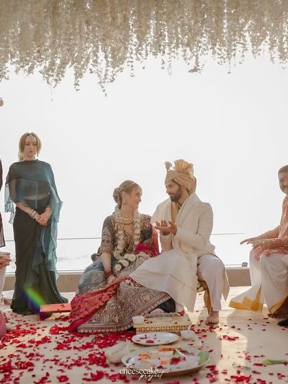 An intimate ceremony on the beach, with close family witnessing the couple's union against the setting sun.