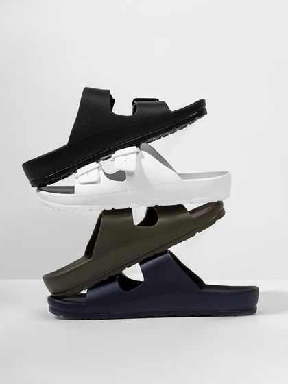 A minimalist stack of four pairs of sandals in different colors. This clean, simple shot is great for showcasing the range of options available.