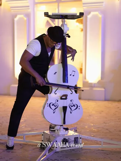 Another angle of the incredible cello stunt act, demonstrating the skill and showmanship of the performer.