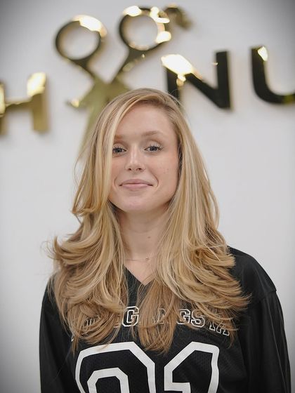 This client is thrilled with her new layered haircut. It's a versatile style that looks great whether it's worn straight or with waves.