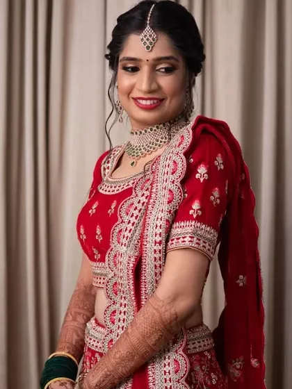 A beautiful portrait of the bride in her red Sangeet lehenga. The intricate hairstyle and glowing makeup complete her look for the evening's festivities.