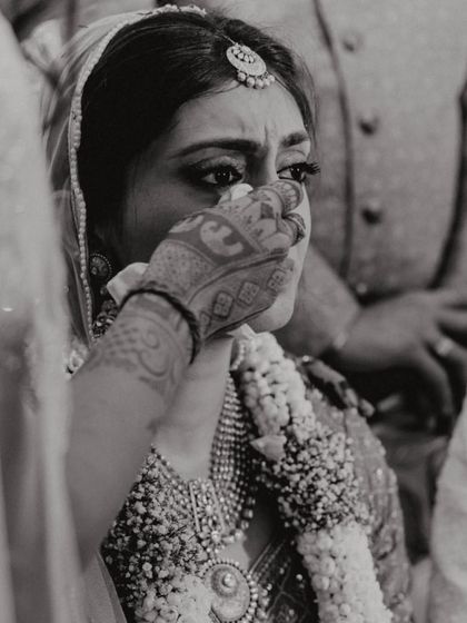 An emotional, black and white close-up of the bride, Shikha, during a poignant moment in her wedding ceremony.