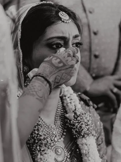 An emotional, black and white close-up of the bride, Shikha, during a poignant moment in her wedding ceremony.