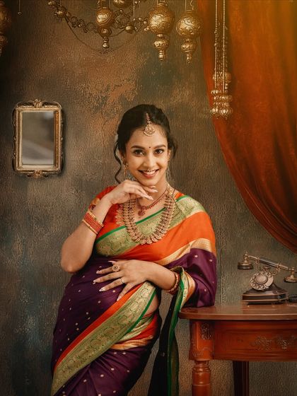 A classic portrait against a vintage-inspired backdrop. The mother-to-be's gentle smile and traditional attire create a look of timeless grace.