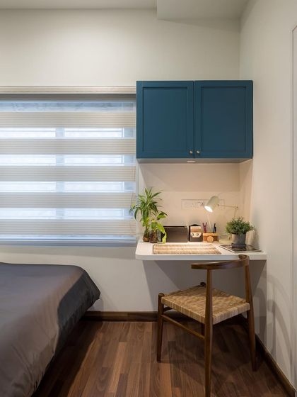 A functional study corner within the kid's room, featuring a floating desk and overhead cabinets to maximize space.